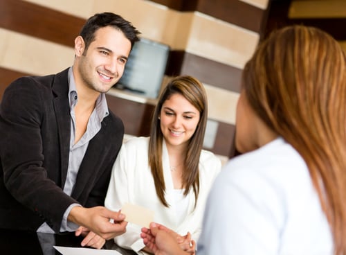 Couple on a business trip doing check-in at the hotel