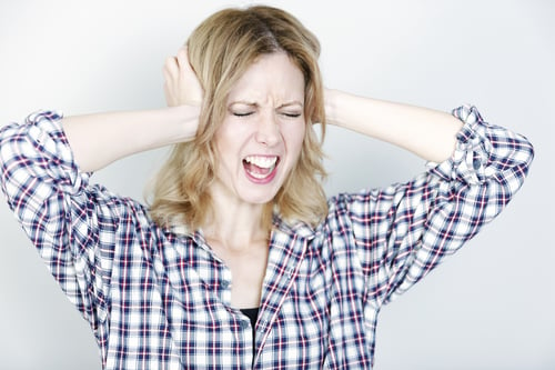 Young woman holding her head looking pained and upset