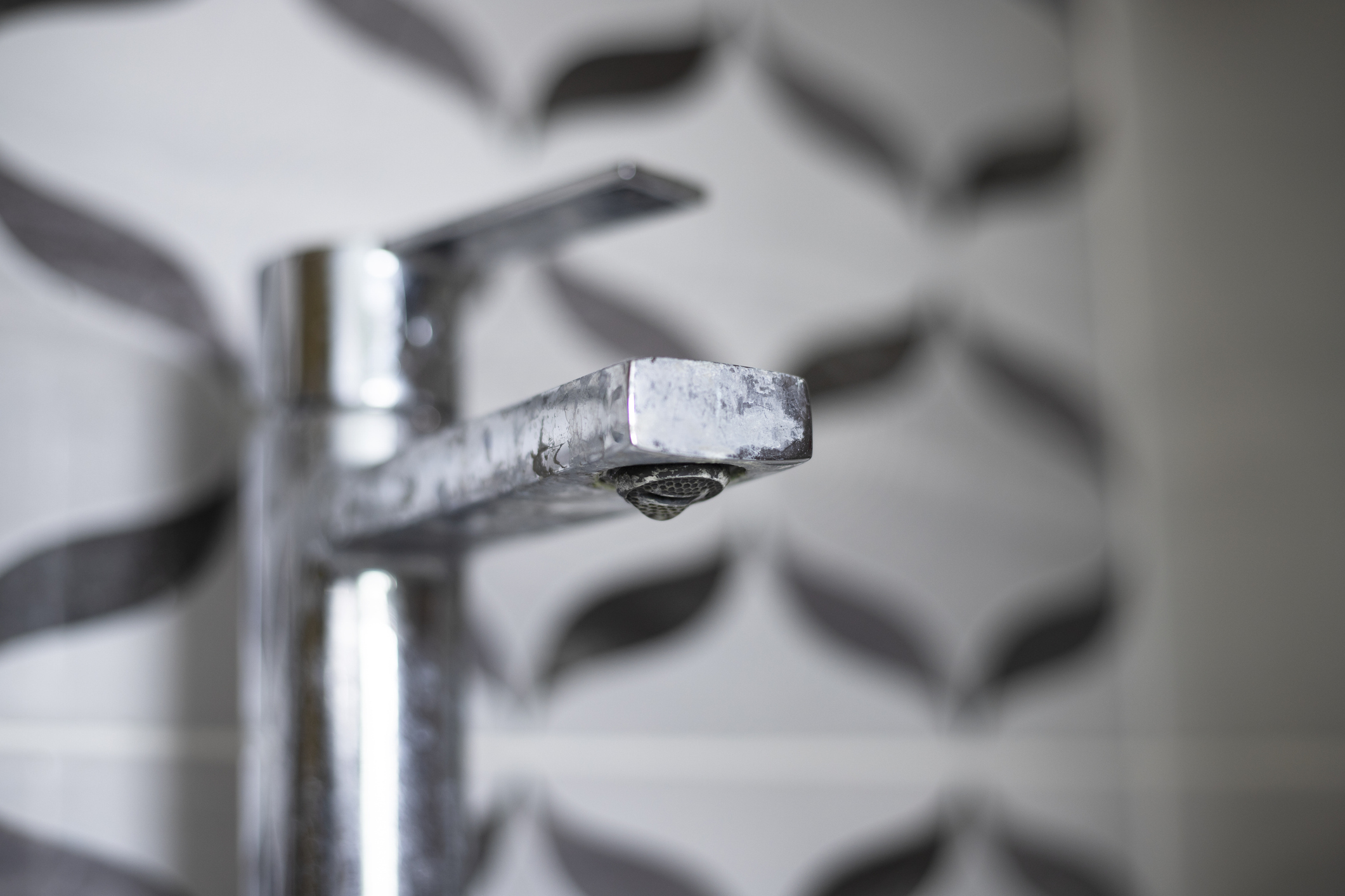 Dirty faucet with hard water stains in bathroom