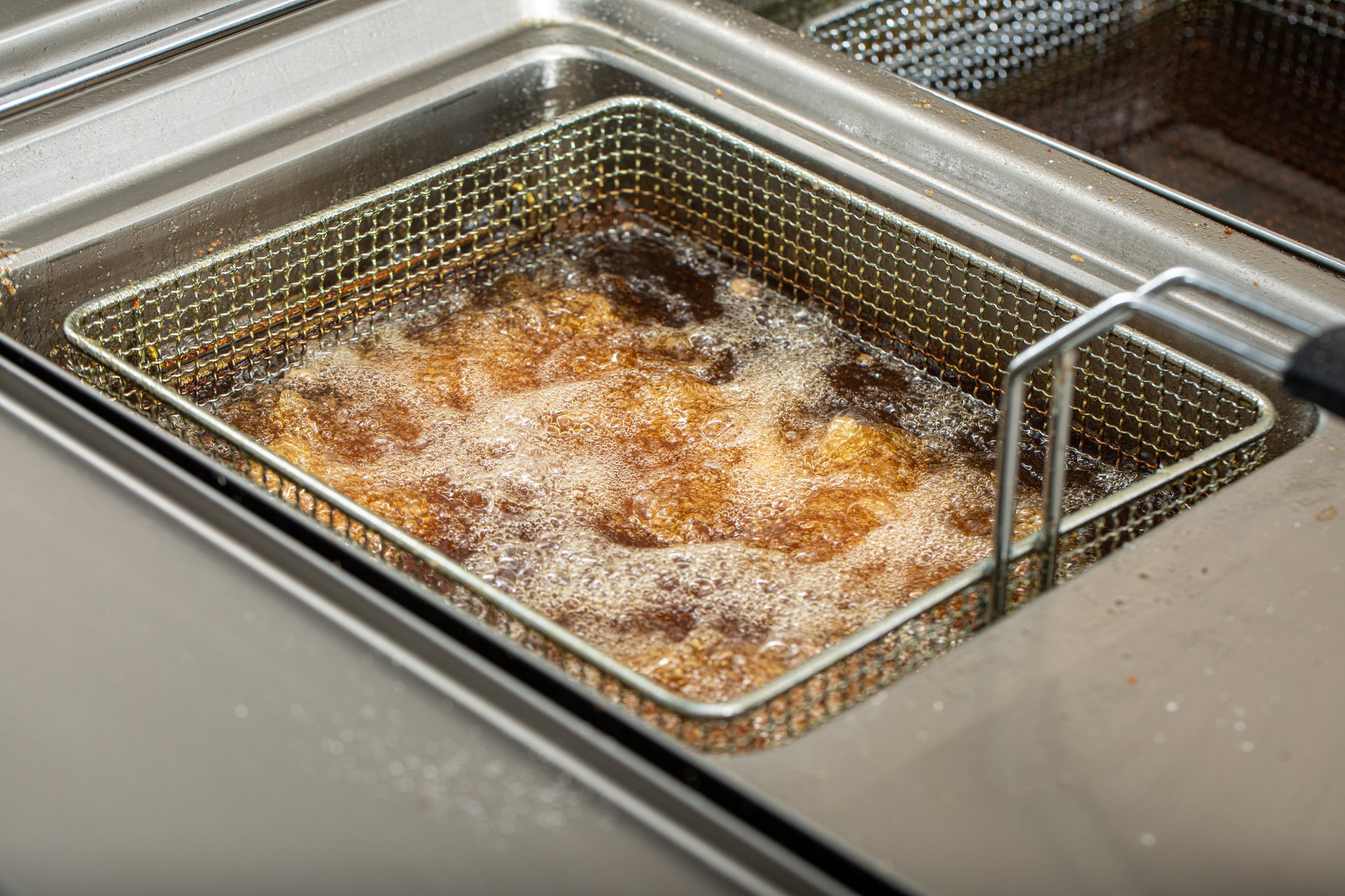 Food in deep fryer in restaurant kitchen