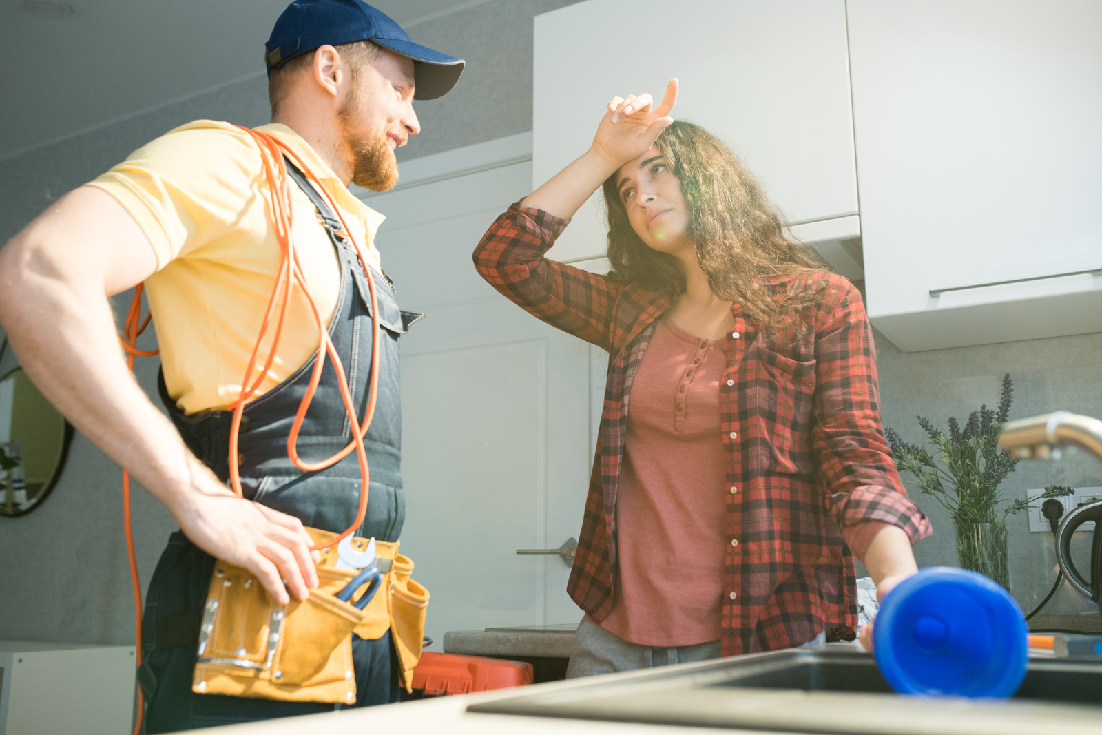 lady and plumber in kitchen with clogged drain